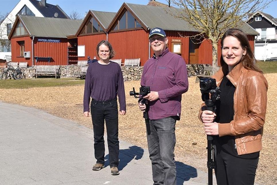 Pastor Johannes Höpfner (von links), Filmproduzent Dirk Tostmann (Pönitz TV) und Kirchenmusikerin Lena Sonntag bei Dreharbeiten im Niendorfer Hafen.