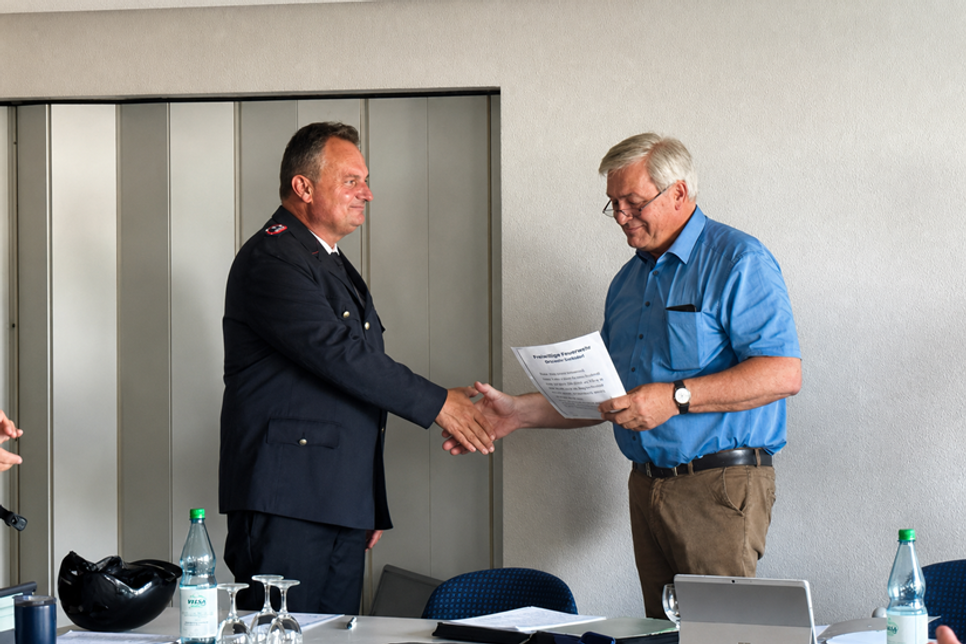 Oliver Woldt wird von Bürgermeister Carsten Bruhn (re.) zum neuen Ortswehrführer vereidigt.