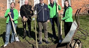 Die SWNH-Azubis Maja Wulf (lks.) und Kaya Siemens (re.) pflanzten gemeinsam mit (v. lks.) Hospitalverwalter Volker Weber, Bürgermeister Mirko Spieckermann und SWNH-Werkleiter Dr. Mark Jahn die Bäume im Hospitalgarten.
