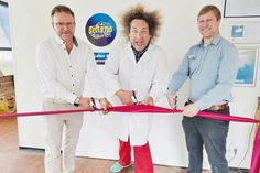 Der 1. stellvertretende Bürgermeister von Timmendorfer Strand, Michael Strümpell (links), Wissenschafts-Comedian Konrad Stöckel und SEA LIFE-Manager Andreas Schulz (rechts) schneiden das rote Band durch.