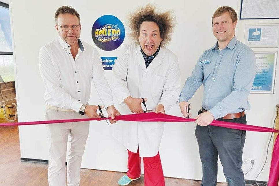 Der 1. stellvertretende Bürgermeister von Timmendorfer Strand, Michael Strümpell (links), Wissenschafts-Comedian Konrad Stöckel und SEA LIFE-Manager Andreas Schulz (rechts) schneiden das rote Band durch.