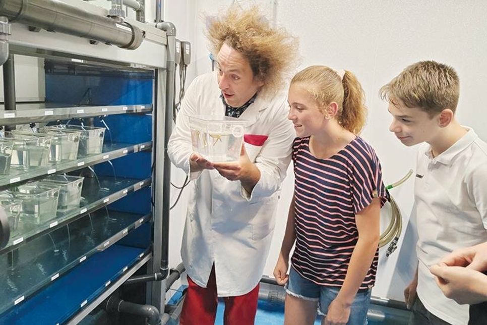 Wissenschaftscomedian Konrad Stöckel mit Mia und Silas „backstage“ im neuen Labor-Bereich.