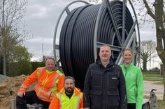 2.500 Meter HDPE Rohr befinden sich auf so einer Trommel. In Merkendorf werden etwa 1.800 Meter davon unter anderem für die Hausanschlüsse des Glasfasernetzes verbaut. Zuständig dafür sind Andre Schabke, Ridvan Dayan und Peter Lehmann, alle von der LB Tele Netz GmbH, Anne Reimers, Bauleitung SWNH (v. lks.). (Foto: Grimm, VS Media)