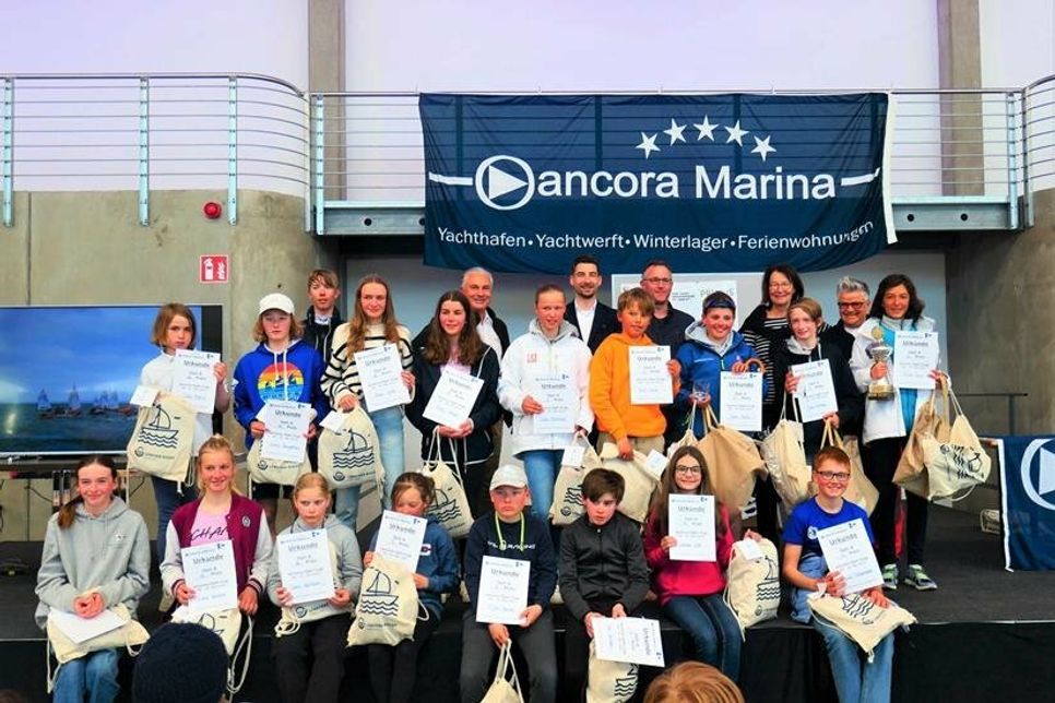 Die Plätze 1 bis 20 Opti A. Schnellstes Mädchen war Aileen Sorg vom NSV (2. Reihe re.), Oliver Seiter (ancora Marina), Jan Schwarzer (Arborea Marina Resort Neustadt), Philip Ismar (NSV, Wettfahrtleiter), Antje Weise (NSV, Jury), Rika Bredehorst (NSV, Regattateam) (3. Reihe von lks.).