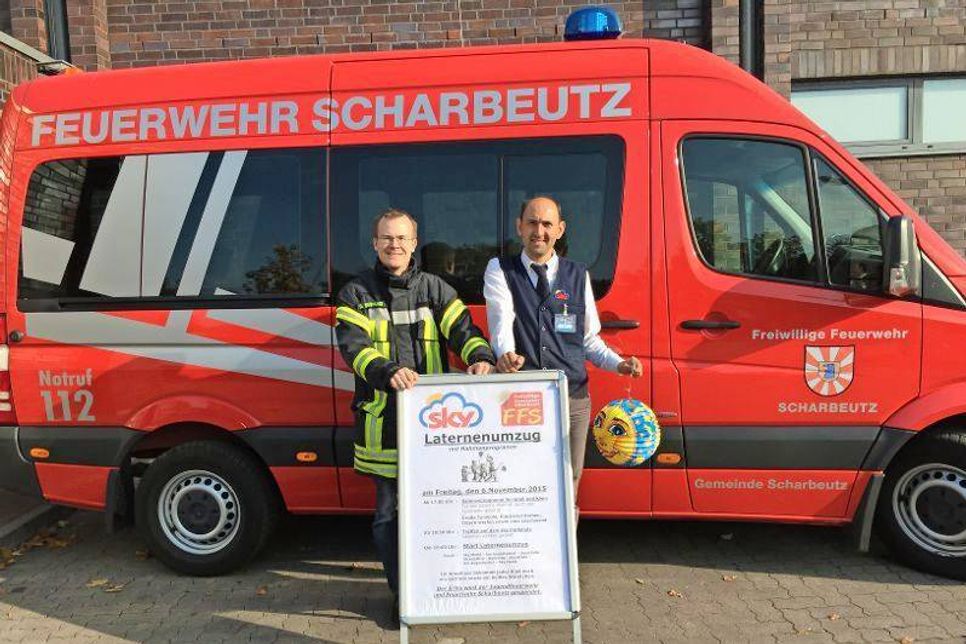 David Siegmund von der Feuerwehr Scharbeutz und Marktleiter Ayhan Deniz (v. lks.) rufen zum Laternenumzug auf.