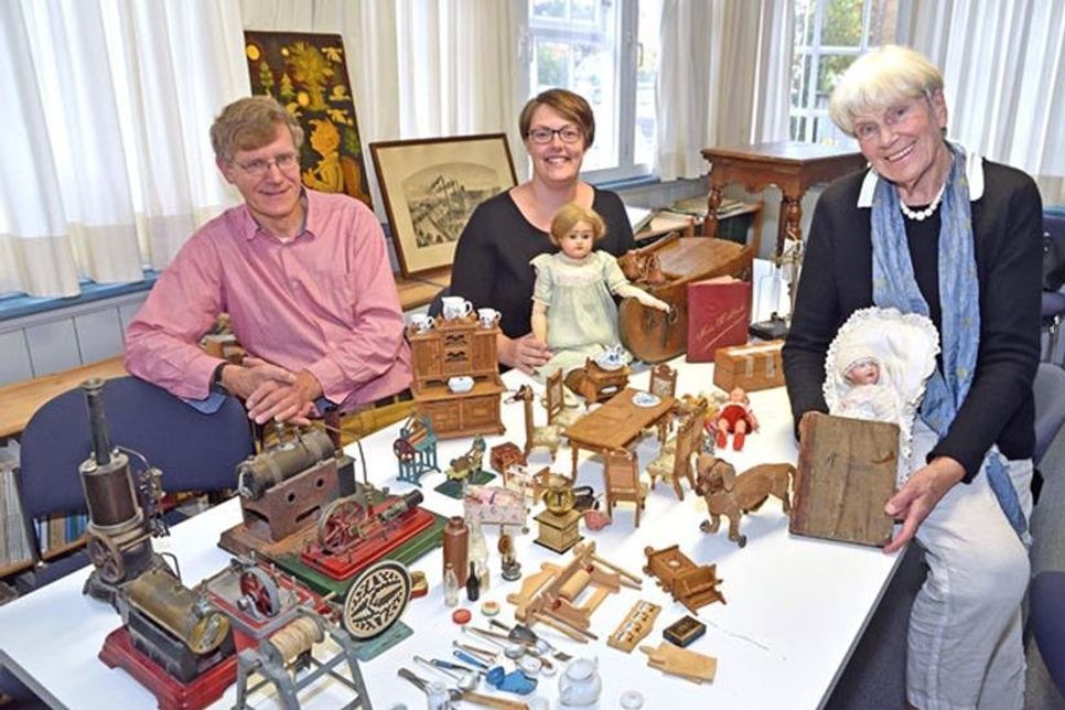 (V. r.) Heinke Heintzen, Ehrenvorsitzende des Heimatvereins Preetz und Umgebung, Jana Burchert, stellvertretende Niederlassungsleiterin Fielmann Plön und Heimatvereinsvorsitzender Axel Langfeldt präsentieren einen reich gedeckten Tisch mit neuen Ausstellungsstücken, die mit Unterstützung der Fielmann Stiftung für das Preetzer Heimatmuseum beschafft werden konnten. Fotos: Schneider