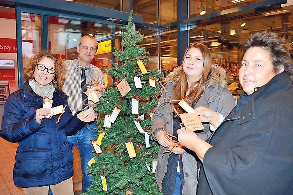 Am 30. November schmückten Gabriele Dede (von links), famila-Warenhausleiter Lars Knoop, Carlotta und Kathrin Wiemer den „Weihnachts-Wunschbaum“ im Eingangsbereich des Warenhauses in Timmendorfer Strand. (Foto: René Kleinschmidt)
