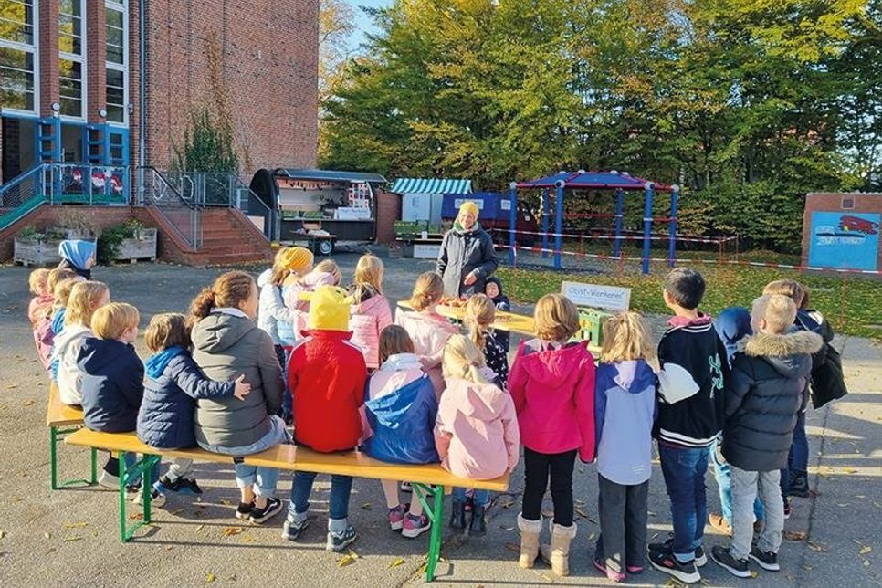 Schulhofunterricht: Klassenlehrerin Irina Hagedorn mit ihrer Klasse lauschen den Worten von  Streuobstpädagogin Meike Barde.