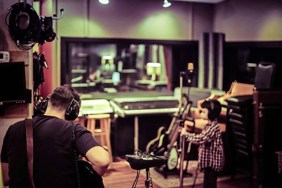 Produzenten und Tontechniker arbeiten abseits der Bühne mit den Künstlern im Studio.