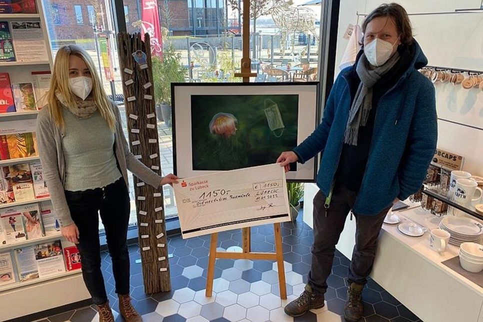 Die junge Travemünder Künstlerin Inga Prasse übergibt die Spende an Thorsten Walter von der Ostseestation Travemünde.