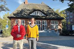 Bürgermeister Sven Partheil-Böhnke und Archivarin Carmen Knickmeier vor dem Strohdachhaus, in dem das Gemeindearchiv untergebracht ist.