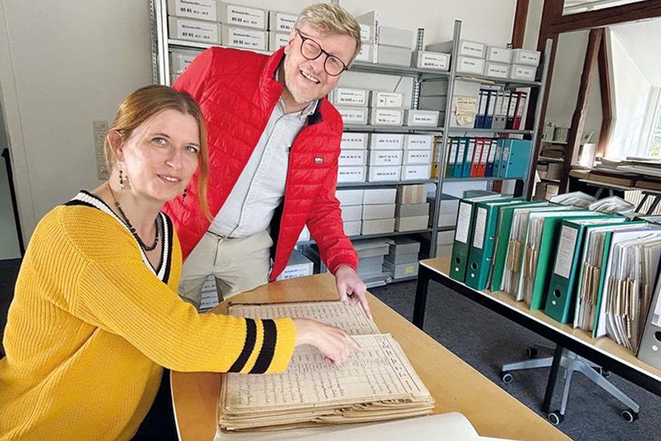 Sven Partheil-Böhnke und Carmen Knickmeier studieren ein Melderegister von 1919.