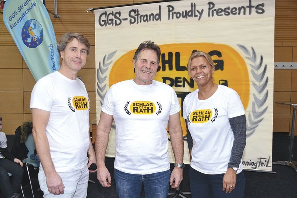 Eine gelungene Überraschung war „Schlag den Rath“ in der Sporthalle: Ekkehard Rawohl und Esther Passig nehmen den zukünftigen Pensionär in ihre Mitte. Das umgestaltete Logo der Fernsehshow, das Graffiti-Künstler Henning Marten Feil auf eine Leinwand verewigte, erhielt Rath als Geschenk. (Foto: René Kleinschmidt)