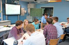 Daniel Borchert und eine Schülergruppe diskutieren eine Grafik am iPad.