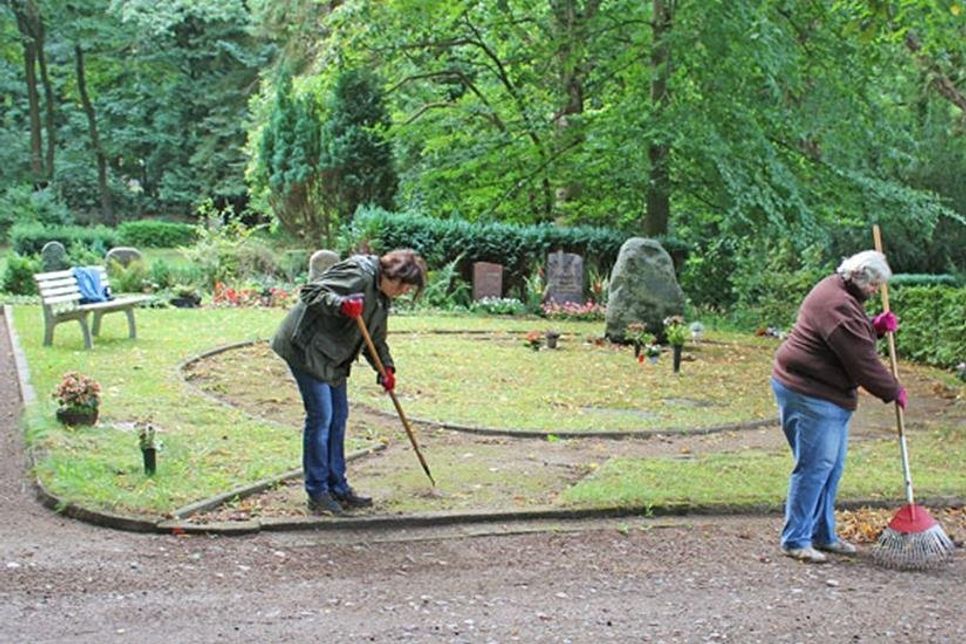 Ellen Heesch (links) befreit gemeinsam mit einer weiteren Freiwilligen die Wege von Laub und groben Steinen