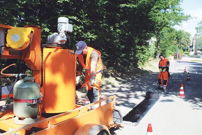 Die Bauhofsmitarbeiter Jakob Kolbe (li.) und Torsten Senf bei der Straßenreparatur. Das Vergussmaterial, das zur Anwendung kommt, ist kostengünstiger und langlebiger als Kaltmaterial.