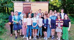 Die Schülerinnen und Schüler der Garten-AG freuen sich mit ihrem Lehrer Philipp Pern (Mitte), Hoteldirektorin Manja Brandt (links), Schulleiterin Dr. Cordula Braun, Bürgermeister Sven Partheil Böhnke und Gesine Muus, Werkleiterin des Kurbetriebes, über ihr neues Gartenhaus, das Dank der Spende erbaut werden konnte.