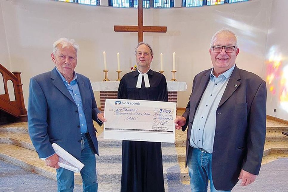 Andreas Müller (rechts), Vorsitzender des Fremdenverkehrsvereins, überreicht den symbolischen Scheck an den Vorsitzenden des Kirchengemeinderats, Ingo Muuss, und Pastor Johannes Höpfner.