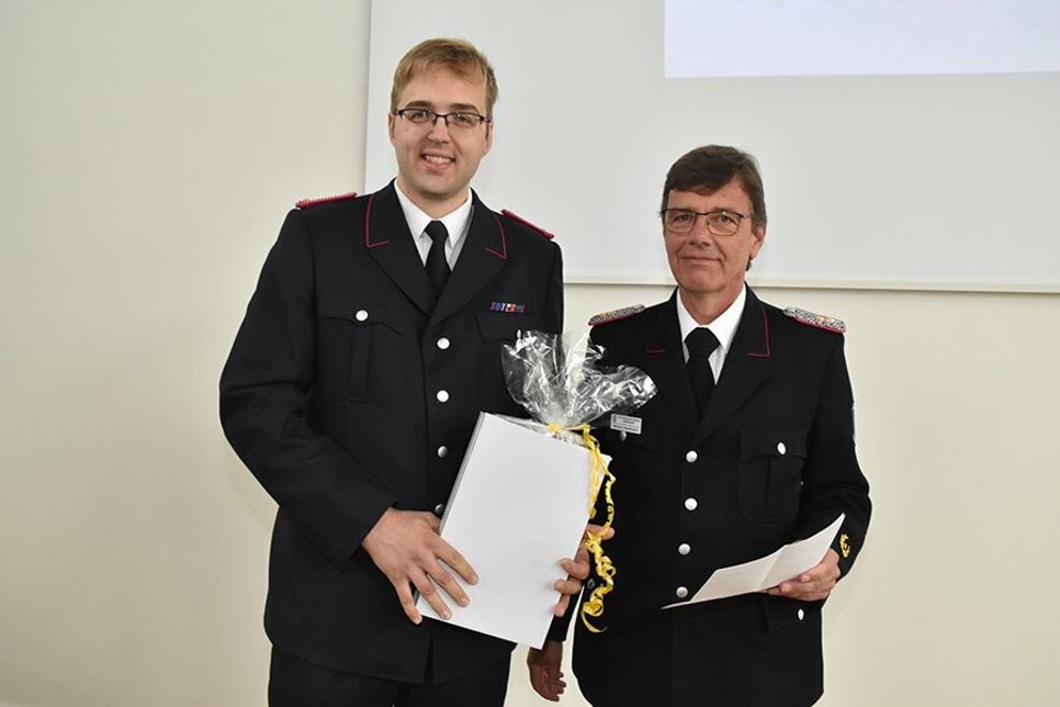 Kreiswehrführer Michael Hasselmann überreicht Ortswehrführer Henrik Nitz (links) eine Uhr des Verbandes, die sicher einen guten Platz im neuen Feuerwehrhaus finden wird.