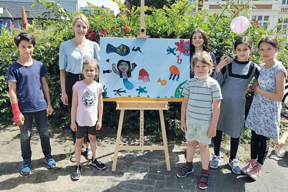 Die Travemünder Künstlerin Inga Prasse mit einigen Kindern, die an dem gemeinsamen Acryl-Kunstwerk, das versteigert wurde, beteiligt waren.