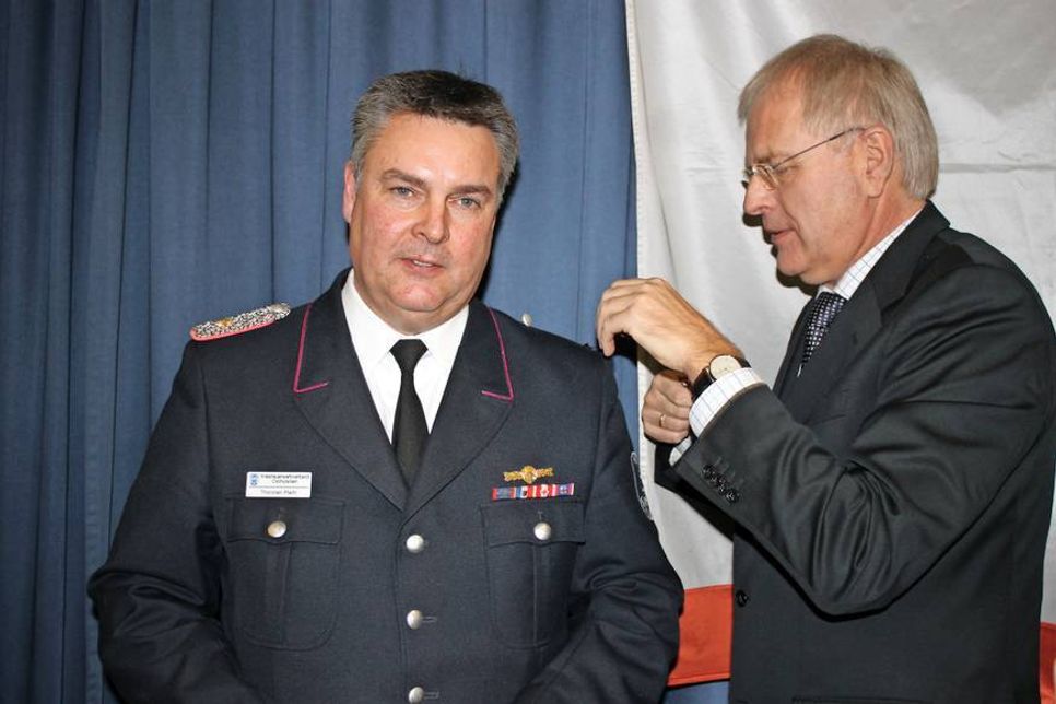 Landrat Sager (re.) beförderte Thorsten Plath zum Ersten Hauptbrandmeister mit einem Stern.