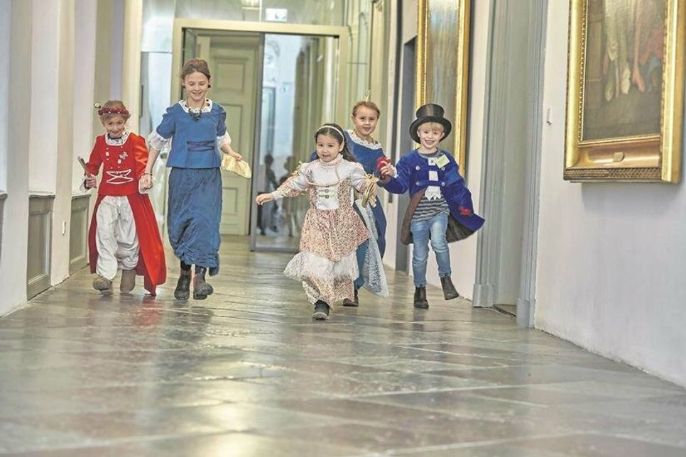 Die Kinder entdecken in märchenhaften Kleidern das große Schloss.