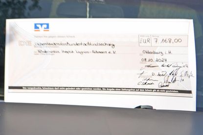 7168,- Euro, dieser Scheck schmückte bei der Geldübergabe die Windschutzscheibe von Chevrolet „Klausi“.