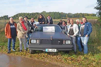 Beate Rinck und ein großer Kreis der US Classics Ostholstein trafen sich zur Geldübergabe an dem Platz, wo das Hospiz entstehen wird.