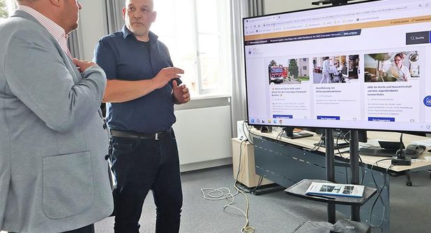Landrat Timo Gaarz  (l) und Digitalisierungsmanager Heiko Nowak (r.) sprechen über die Möglichkeiten der neuen Engagementbörse.