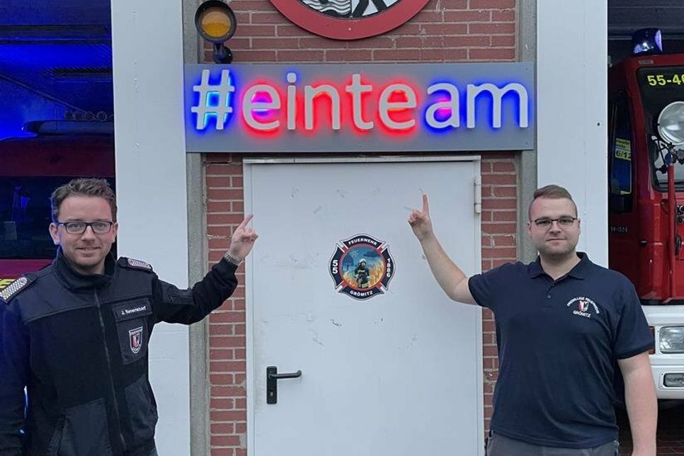 Der #einteam-Schriftzug über der Tür zur Fahrzeughalle. Kamerad Daven Schöning (re.) und Ortswehrführer Jacob Revenstorf sind stolz.