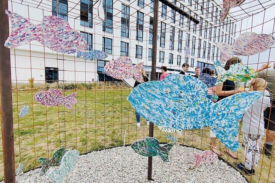 Die Plastikfische aus dem Passathafen „schwimmen“ nun am Leuchtenfeld in einem Stahlkäfig und erinnern an die Verschmutzung der Meere.