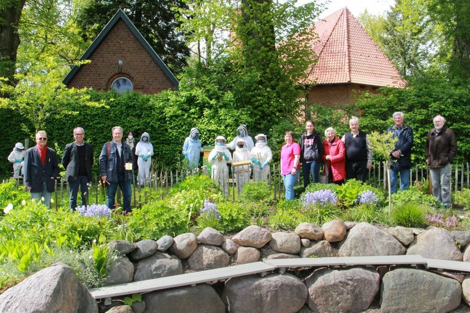 Bürgermeister Winfried Saak, Pastor Dr. Arnd Heling und Klaus-Martin Bresgott vom Kulturbüro des Rates der EKD (v. lks.) mit den Imkerkindern und den Projektpartnern aus Kirchengemeinde und Schulverband.