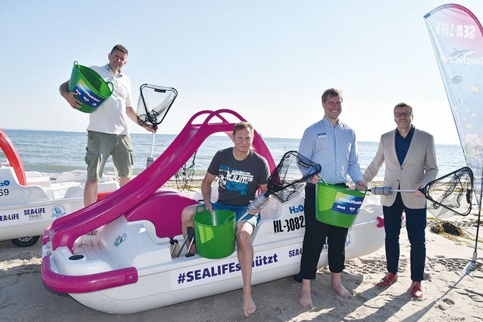 Tretbootvermieter Marcus Bade (von links), Schauspieler Fabian Harloff, SEA LIFE-Manager Andreas Schulz und Bürgermeister Sven Partheil-Böhnke mit einem Tretboot der #SEALIFEschützt-Flotte.