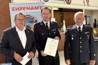 Bürgermeister Sebastian Rieke (lks.) und Bürgervorsteher Matthias Dammer (re.) vereidigten Jacob Revenstorf für weitere sechs Jahre zum Ortswehrführer.