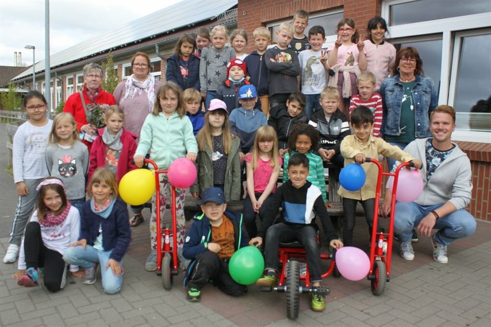 Ein Teil der Insel-Kinder mit der DRK-Vorsitzenden Ingrid Graaf, der Fördervereins-Vorsitzenden Nicole Paustian, Insel-Leitung Christel Albrecht und dem stellvetrtenden Schulleiter Matthias Thomas bei der Spendenübergabe.