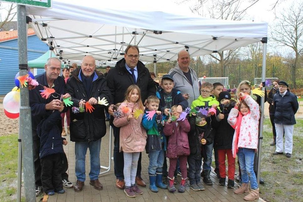 Bürgervorsteher Sönke Sela und Bürgermeister Mirko Spieckermann und Stadtjugendpfleger Norbert Mohwinkel (hinten re.) durchschnitten mit Kindern symbolisch das Band.