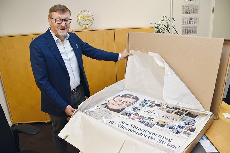 Sven Partheil-Böhnke beim Auspacken eines Überraschungsgeschenks: Eine große Collage, die an den Wahlkampf erinnert.