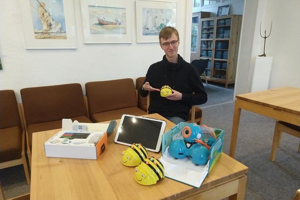 Mitarbeiter der Stadtbücherei Janek Beckmann mit BeeBot.