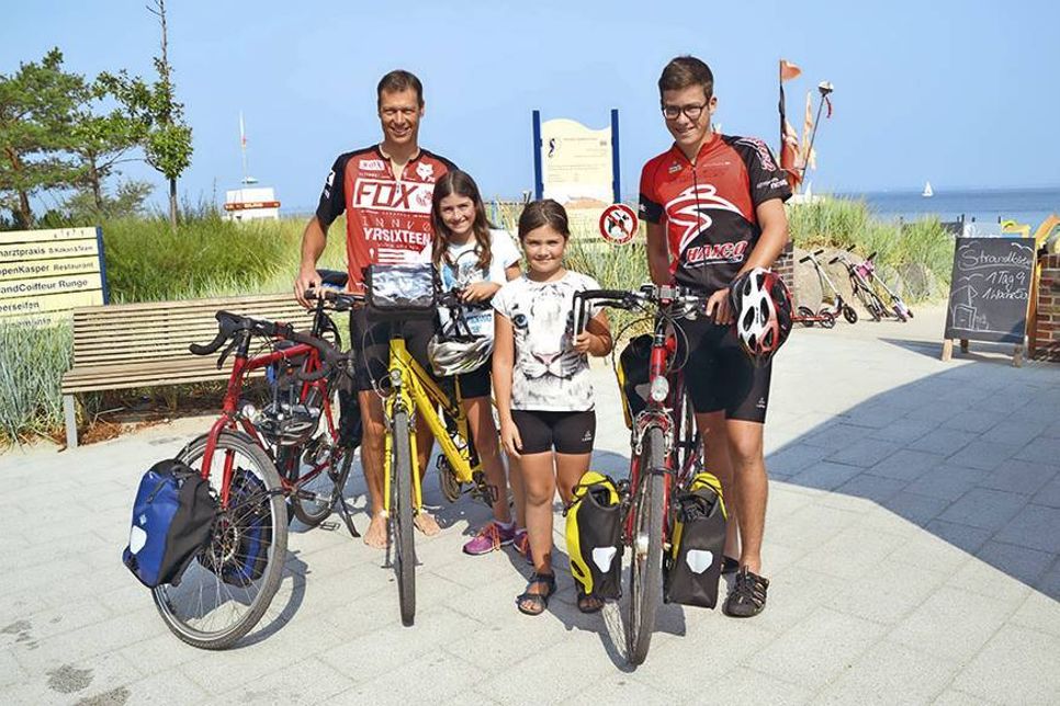 Zufrieden und stolz nach ihrer 660 km-Radtour von Dresden an die Ostsee: Dr. Urs Riemann (47, links) und seine Töchter Bente (9) und Mette (7, 2.v.re.) und Sohn Nils (14) mit ihren Trekking-Rädern am Strandabschnitt von Katja Frank in Niendorf/Ostsee.