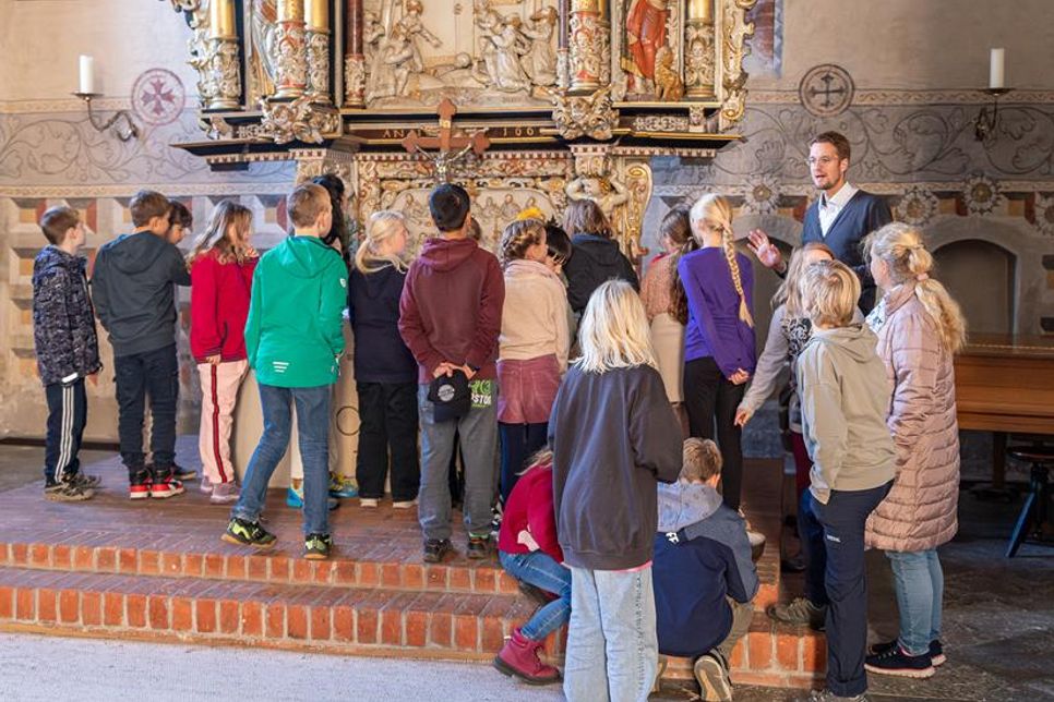 Die Kinder lauschten aufmerksam den Erklärungen des Pastors vor dem Altar der Stadtkirche.