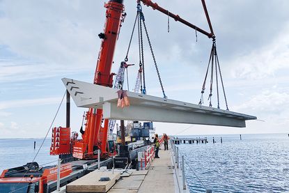 April 2024: Das erste 45 Tonnen schwere Stahlbetonfertigteil der nördlichen Balkone schwebt über der Scharbeutzer Seebrücke.