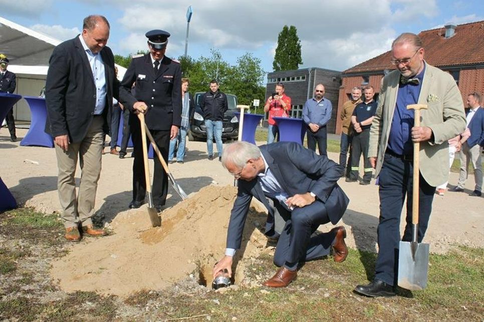Landrat Reinhard Sager (vorne), zukünftiger Landrat Timo Gaarz (lks.), Kreispräsident Harald Werner (re.) und Kreiswehführer Michael Hasselmann nahmen die feierliche Grundsteinlegung vor. Um der Nachwelt einen Eindruck von der Lebenswelt zum Zeitpunkt der Grundsteinlegung und vom zu errichtenden Gebäude zu geben, wurden aktuelle Medienerzeugnisse, ein Bauplan, ein Bild von der Baustelle sowie ein aktueller Euro-Münzsatz beigelegt.