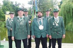 Schützenkönig Oliver I. Thoms (Mitte) sowie seine Ritter Dirk Samelin (links) und Dirk Gutschow freuen sich auf ein harmonisches Schützenfest zum Ende ihrer Regentschaft. Im Hintergrund die Fahnenabordnung mit der Traditionsfahne der Scharbeutzer Schützen.