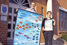 Maria Starke (Bürgerverein Stockelsdorf) und Klimamanager Manuel van der Poel präsentieren vor dem Rathaus das Poster, mit dem die Aktion beworben wird, sowie eines der Ausstellungsstücke. Foto: VA/hfr