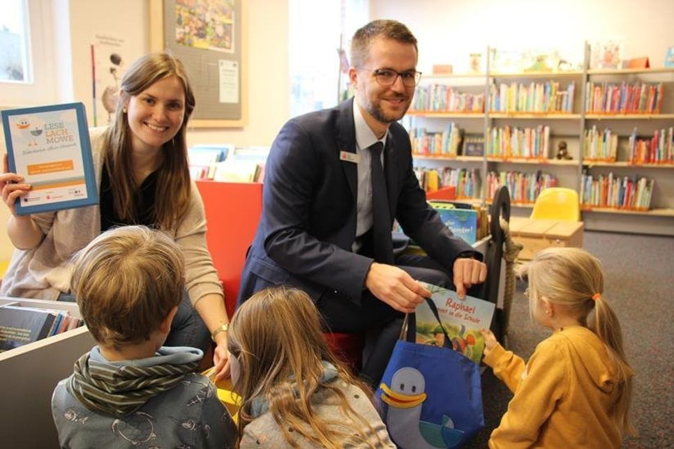 Laura Dorittke (Stadtbücherei) und Tim Dummer (Sparkasse) zeigten den Kindern aus dem Jona Kindergarten den wertvollen Inhalt der bunten Taschen.