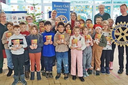 Schüler der Klasse 2 b präsentieren ihre neuen Bücher; im Hintergrund (v.l.n.r): Schulleiterin Gesine Böllnitz, Klassenlehrerin Frau Kirsten Looks, Projektleiterin Susanne Knees und die Rotarier Dr. Horst Simonsen und Dr. Dieter Fischer