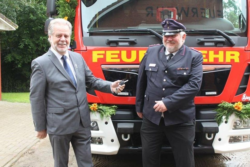 Bürgermeister Rainer Holtz bei der Schlüsselübergabe an Ortswehrführer Rolf Willert (re.).