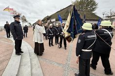 Pater Ralf Winterberg segnet auf dem Nystedplatz in Dahme die neue Fahne der Freiwilligen Feuerwehr.