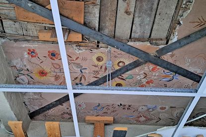 Unter der abgehängten Decke finden sich noch Spuren der ursprünglichen, mit Blumenmustern bemalten Strohdecke.