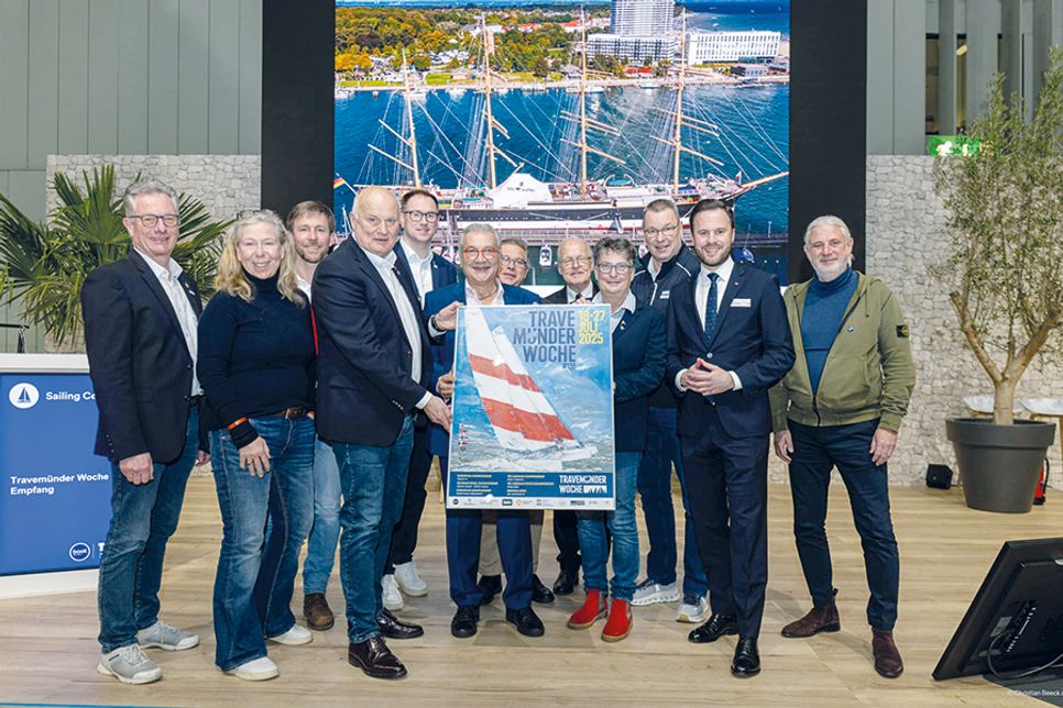Die Organisatoren der Travemünder Woche stellen das frische Plakat zur TW 2025 vor: Lutz Kleinfeldt (von links), Anja Kamrath, Lorenz Buchler, Frank Schärffe, Jan Lindenau, Petros Michelidakis, Sascha Osterwalder, Andreas Christiansen, Frauke Klatt, Jens Kath, Marius Berlemann und Ralf Schulte.